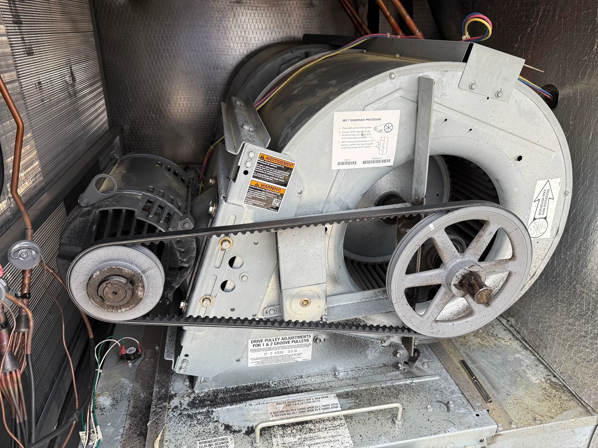 HVAC blower motor assembly with pulleys, belt drive, and replacement components during installation