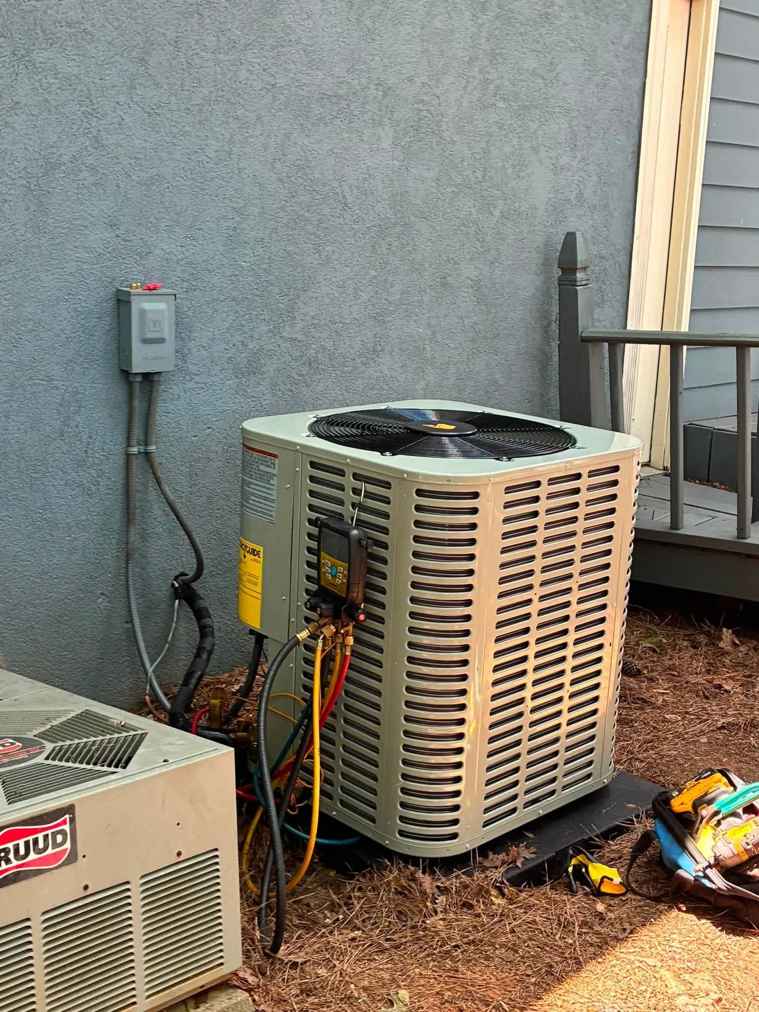 A Legacy HVAC Services technician collecting an air sample in a Hampton, GA home with visible ductwork in the background. The image shows handheld testing equipment being used in a residential living space.